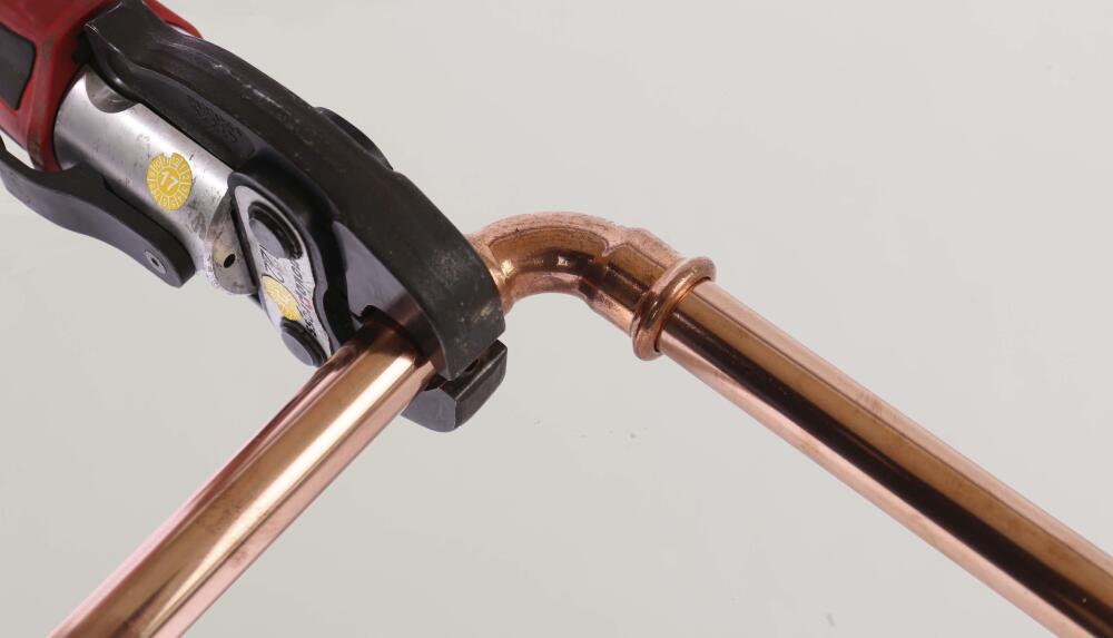 Image showing an installer crimping the M Press profile Copper Fitting