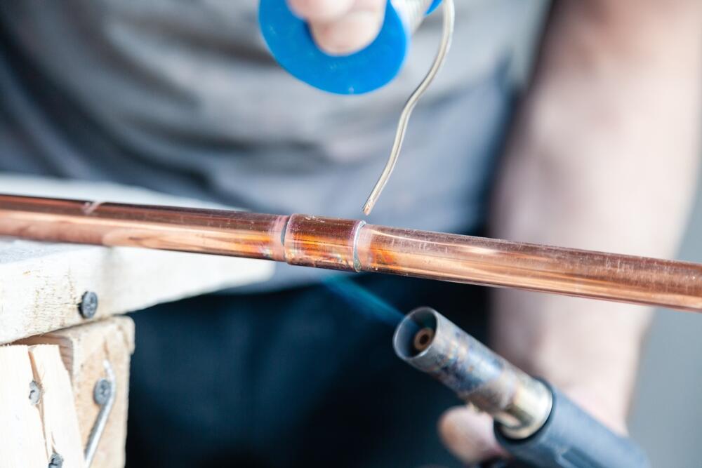 Image demonstrating an installer soldering an End Feed coupling