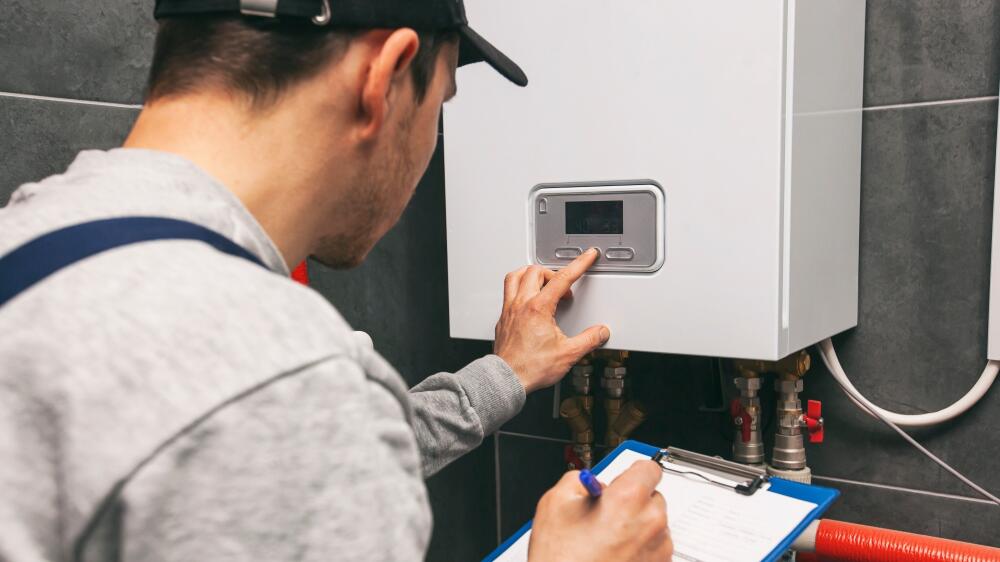 Installer checking boiler after having installed the system